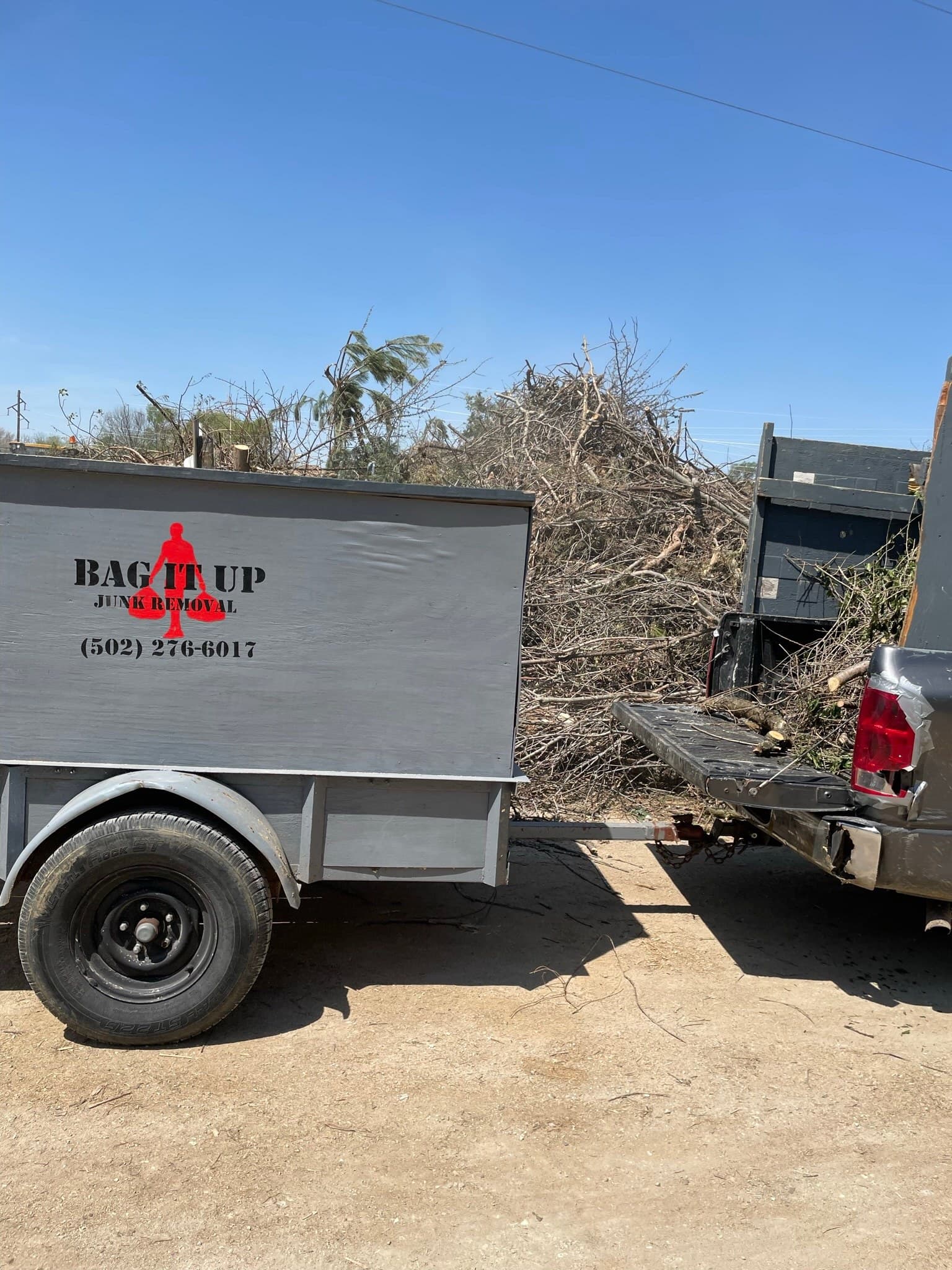 Bag It Up trailer and truck loaded with brush for removal